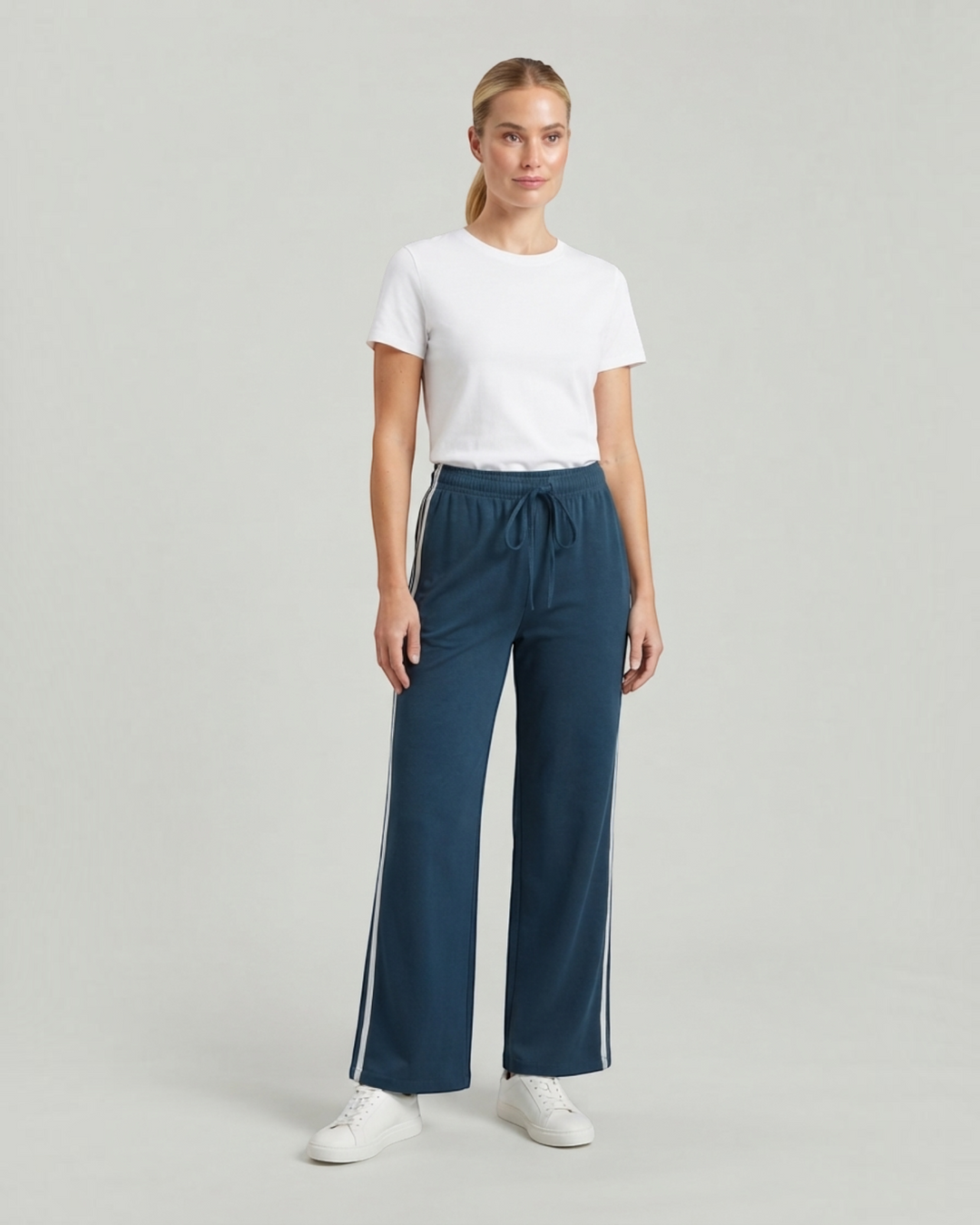 Luna Moda wide-leg athleisure sweatpants in blue with side stripes and drawstring waist worn by a woman