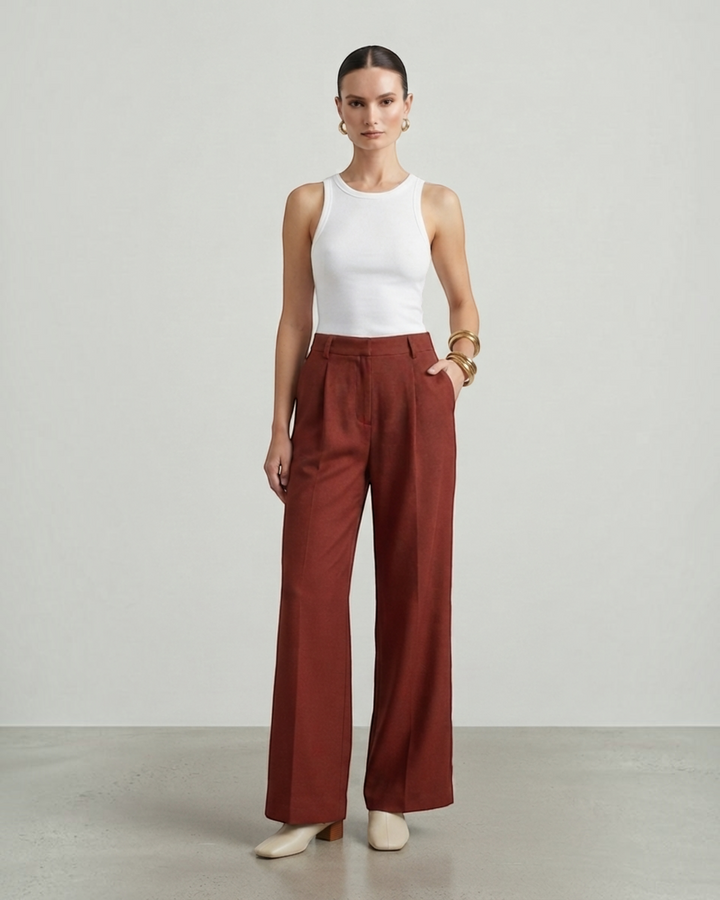 Luna Moda Stefania high-waisted wide-leg trousers in rust brown with front pleats worn by a model with a white tank