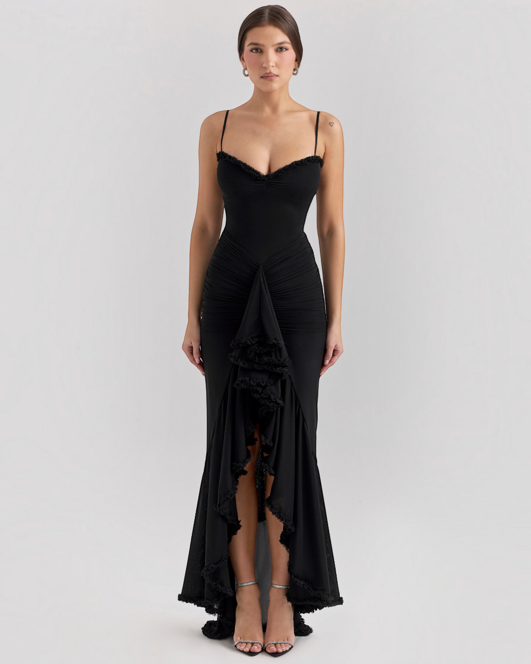 Luna Moda Edith black evening dress with spaghetti straps, ruched bodice, and high-slit ruffled hem on a model