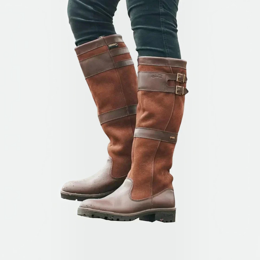 Luna Moda brown leather knee-high boots with double buckle straps and rugged lug soles worn by a person