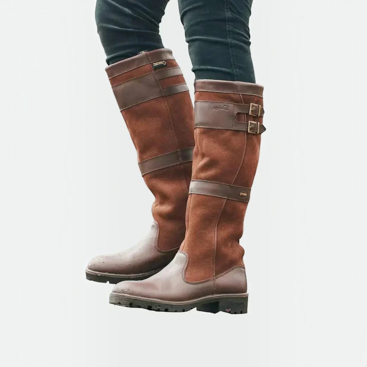 Luna Moda brown leather knee-high boots with double buckle straps and rugged lug soles worn by a person