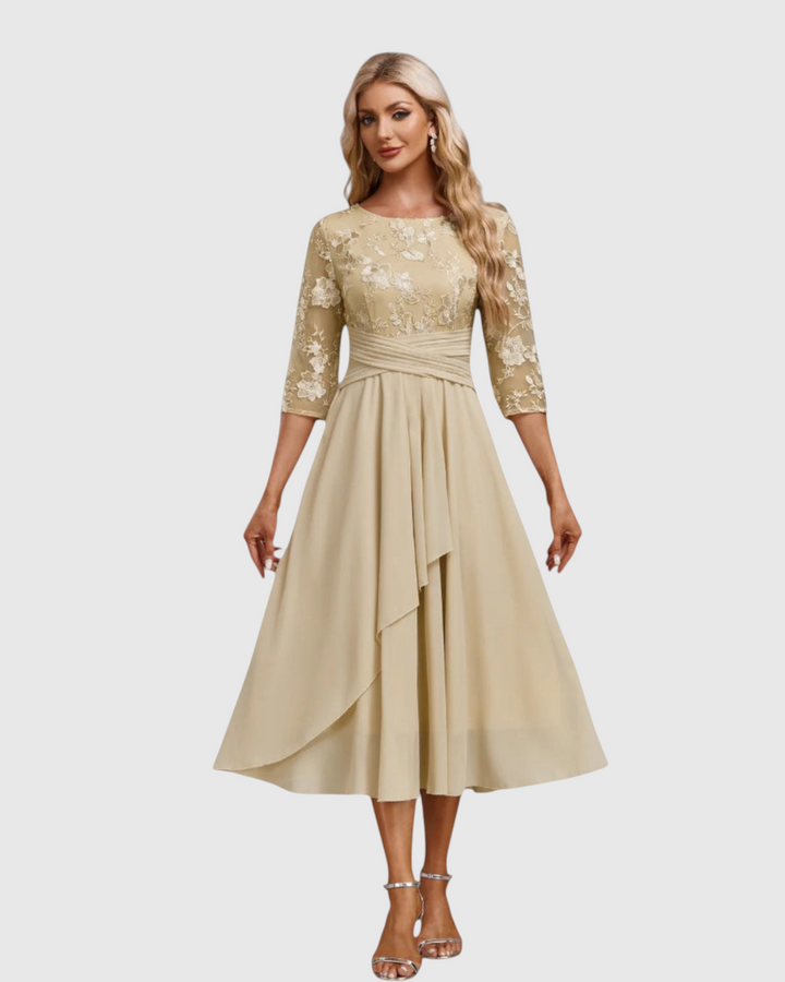 Luna Moda beige midi dress with short lace sleeves and a pleated waist, worn by a blonde model on a white background.