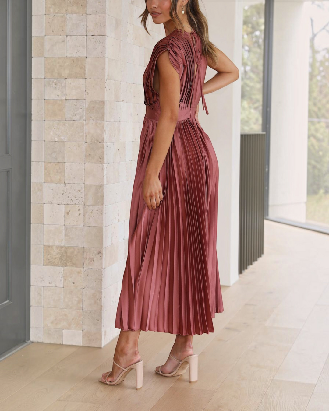 Luna Moda Isla rose red pleated midi dress with high waist and draped V-neck worn by a model in a bright interior