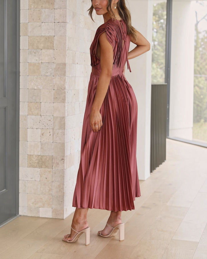 Luna Moda Isla rose red pleated midi dress with high waist and draped V-neck worn by a model in a bright interior
