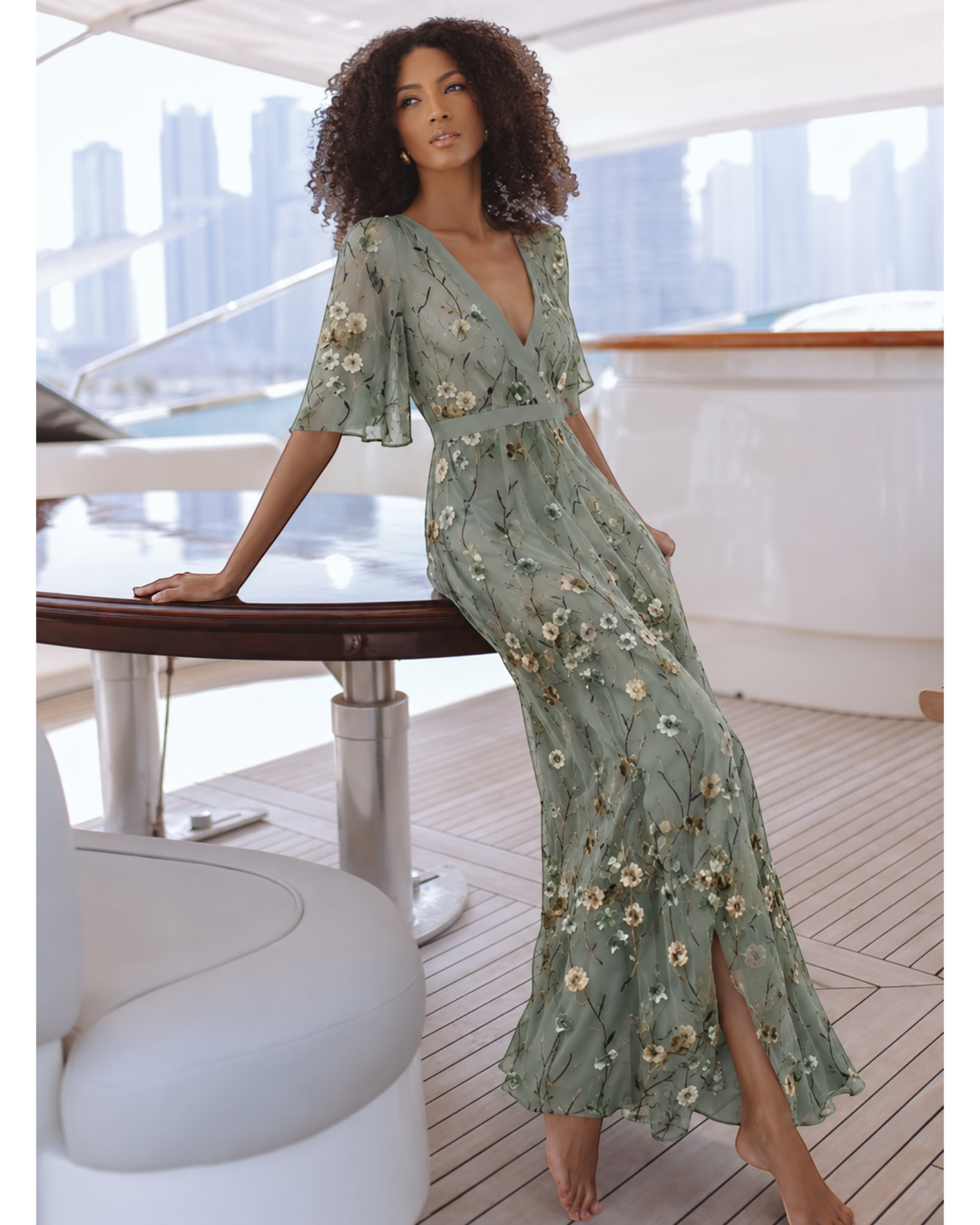 Luna Moda Valentina sage green floral maxi dress with deep V-neck and flutter sleeves worn by a model on a yacht