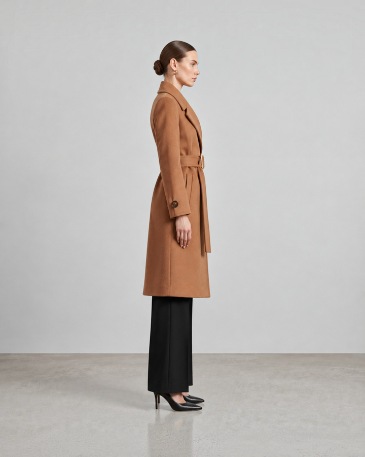Luna Moda long camel wool coat with a belted waist worn by a model in profile view with black trousers and heels.
