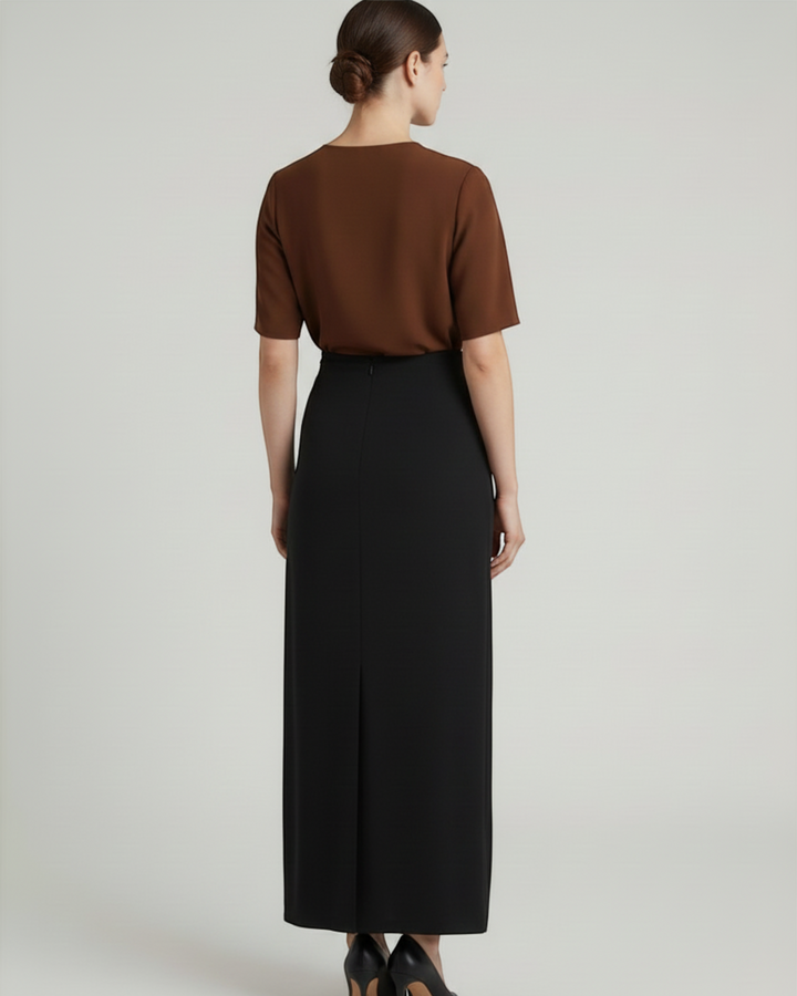 Luna Moda Cleo midi skirt in black worn with a brown top, showing a sleek silhouette from the back view