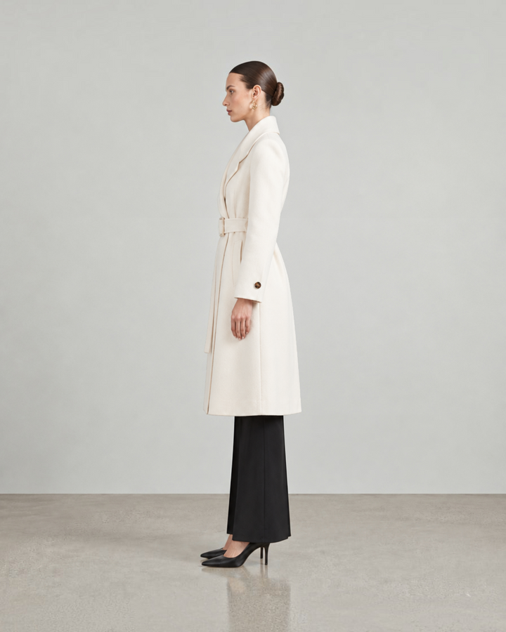 Luna Moda LISABETTA long cream wool coat with a belted waist worn by a model in a side profile view