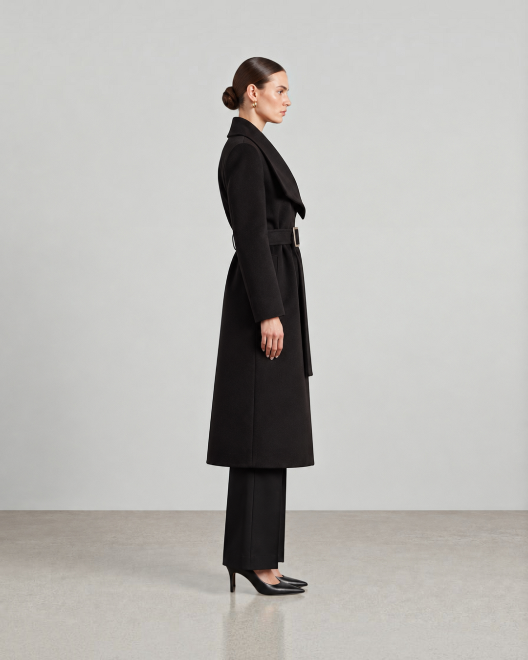 Luna Moda Lisabetta long black belted coat worn by a model in profile, featuring a wide collar and elegant silhouette.