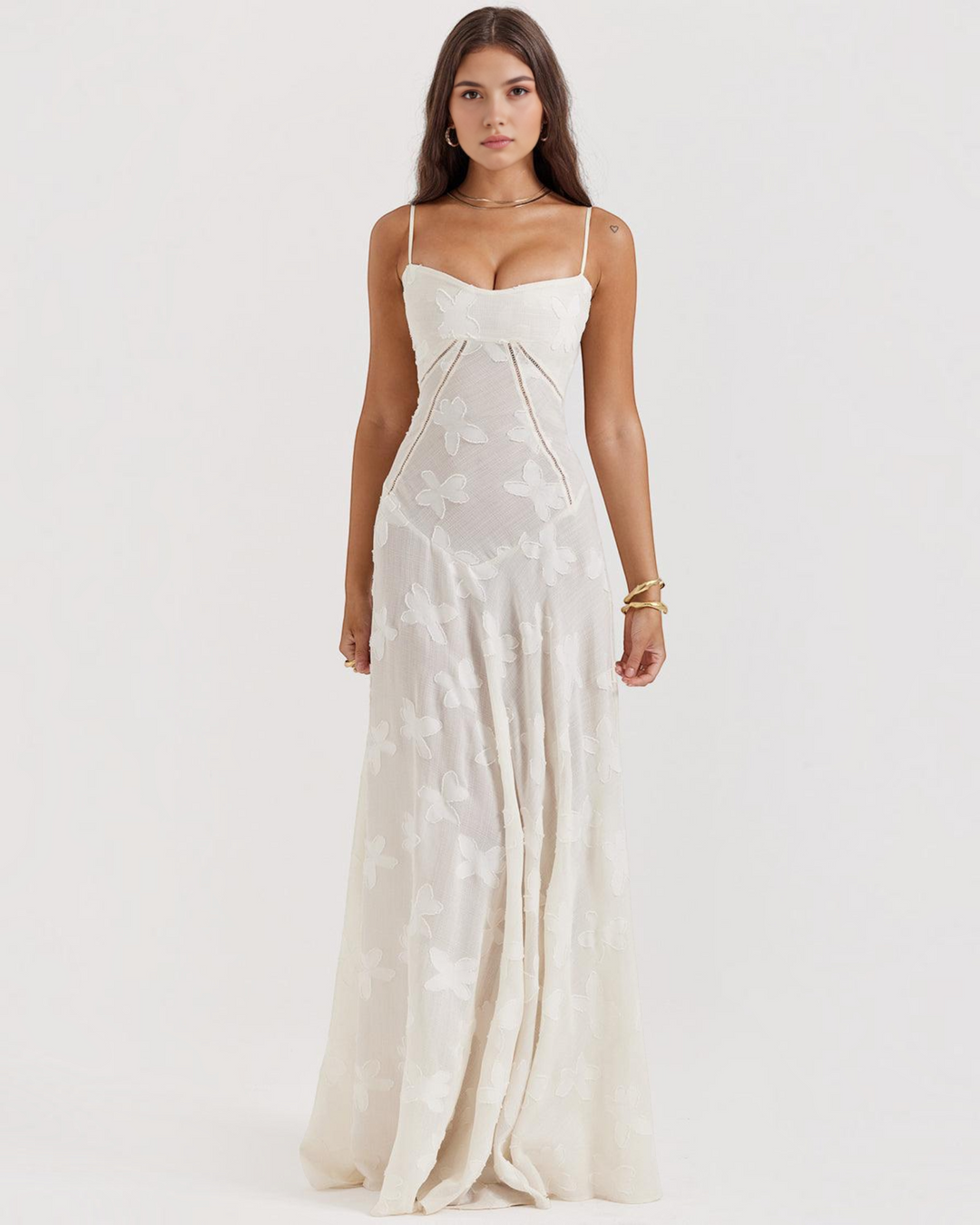 Model wearing a Luna Moda white maxi dress with a sweetheart neckline, spaghetti straps, and floral texture.