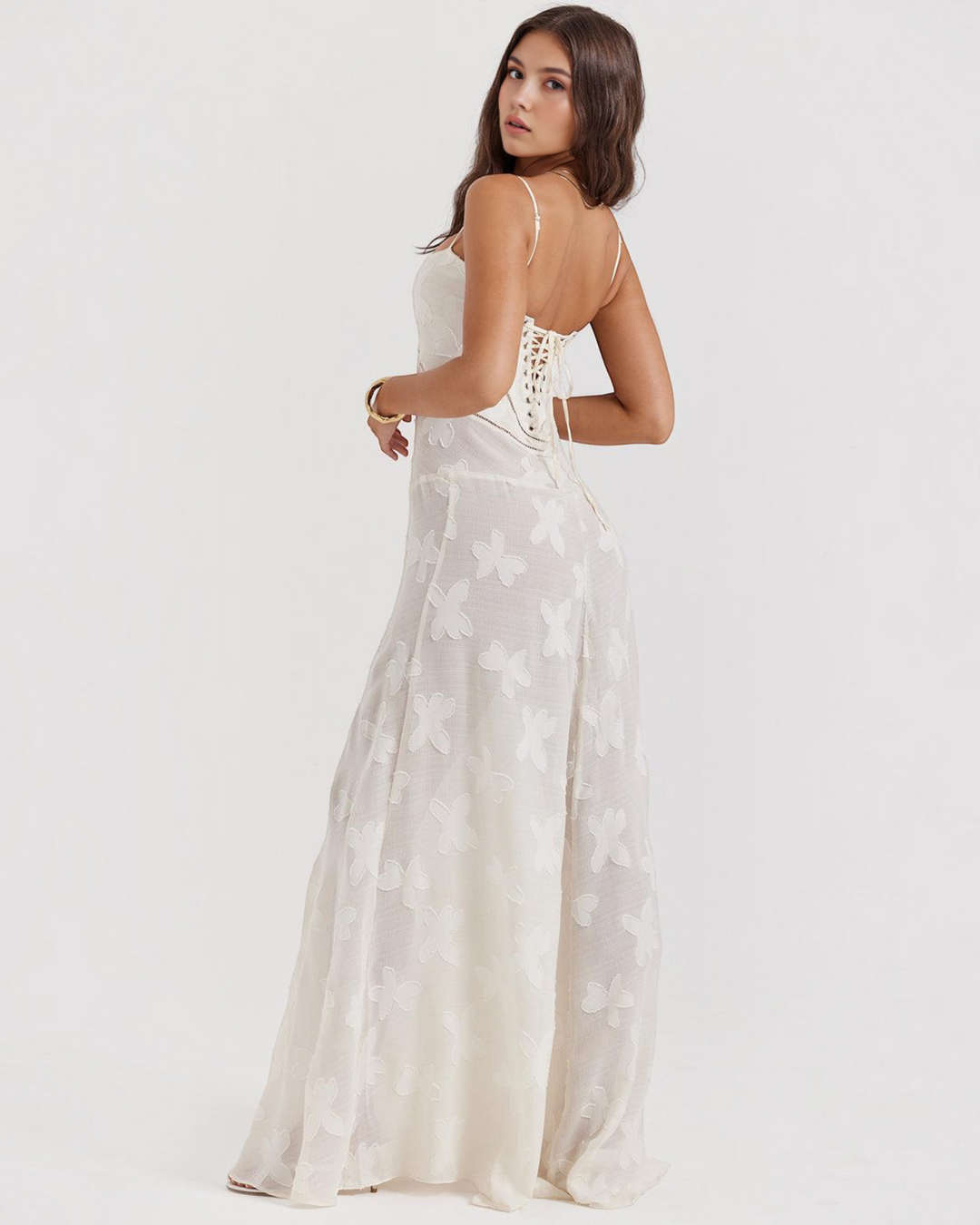 Luna Moda white maxi dress with floral texture, corset-style lace-up back, and spaghetti straps on a model