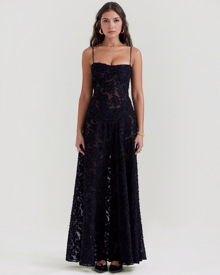 Luna Moda Seren evening dress in black floral velvet with delicate spaghetti straps on a model against a plain backdrop