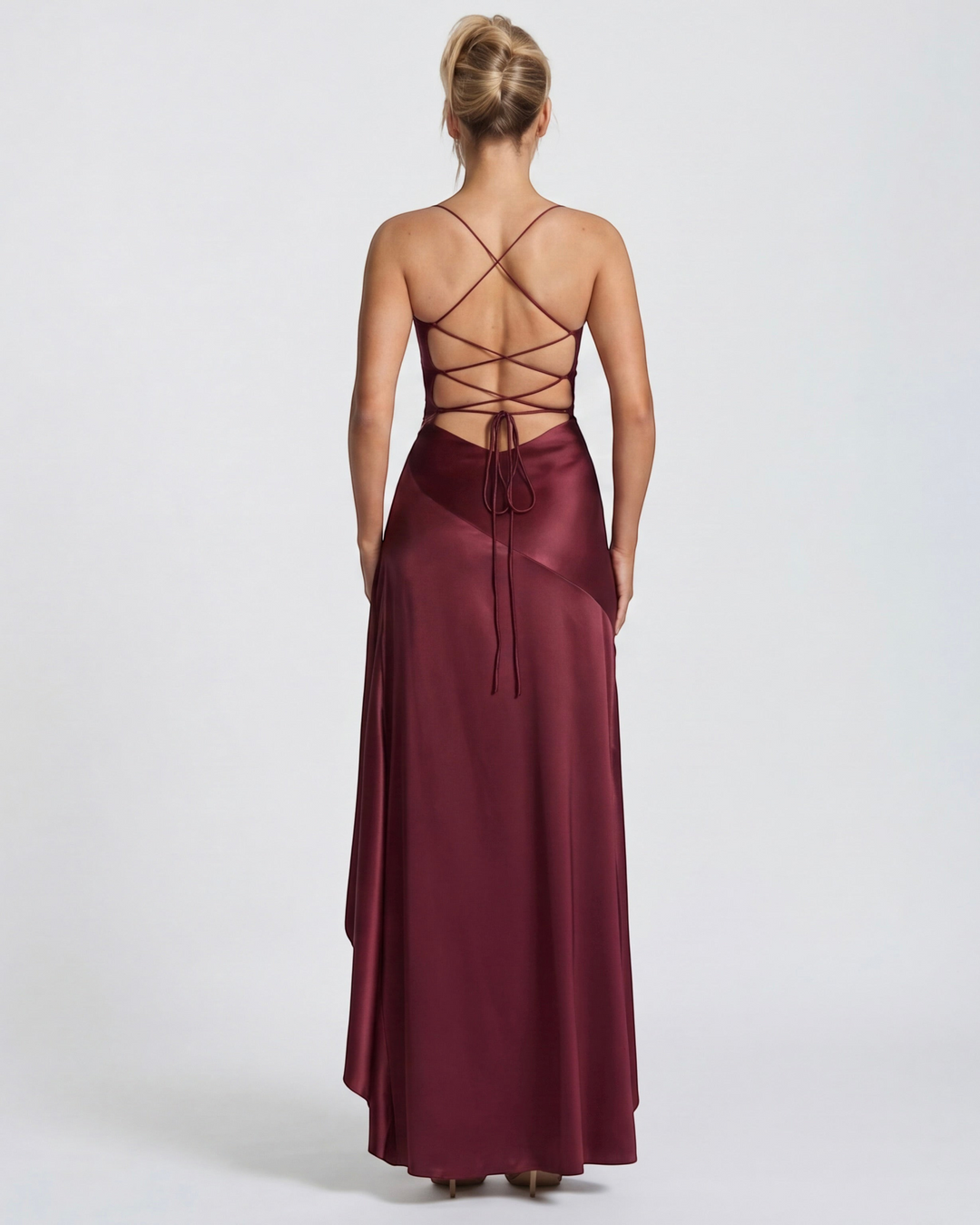 Back view of a Luna Moda red satin evening gown with a lace-up open back, spaghetti straps, and draped skirt.