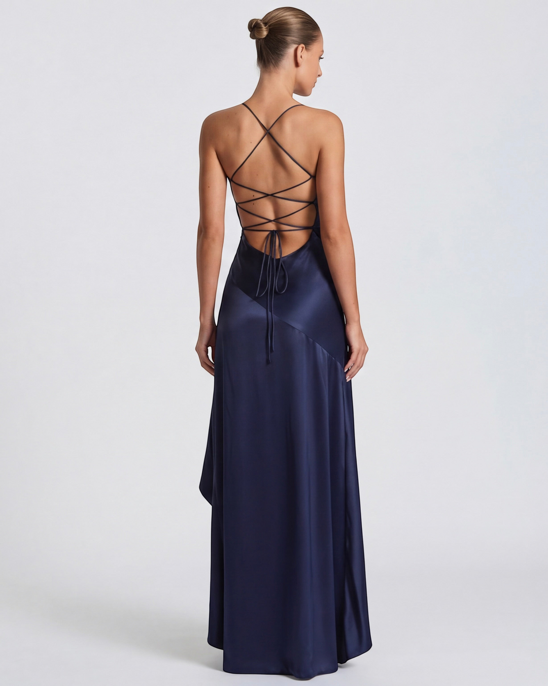 Luna Moda Muse navy blue satin evening gown with a draped back, high slit, and adjustable crisscross tie straps.