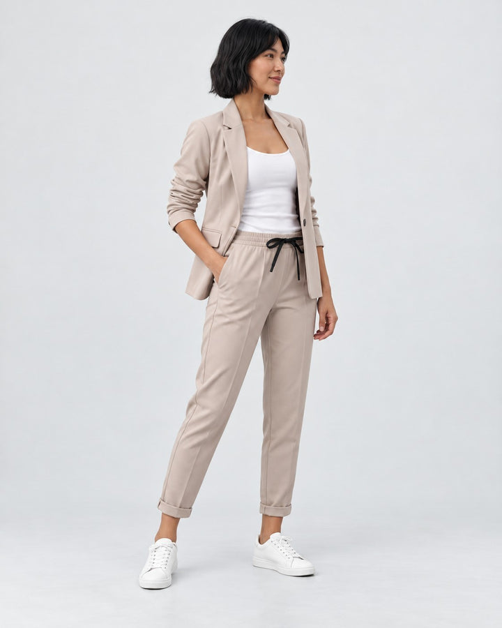 Luna Moda Adriana beige fluid blazer and elastic waist trousers set worn by a woman with white sneakers