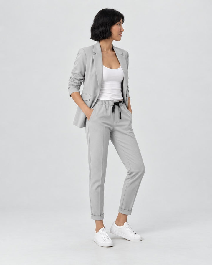 Luna Moda Adriana light grey fluid blazer and elastic waist trousers set worn by a woman with white sneakers