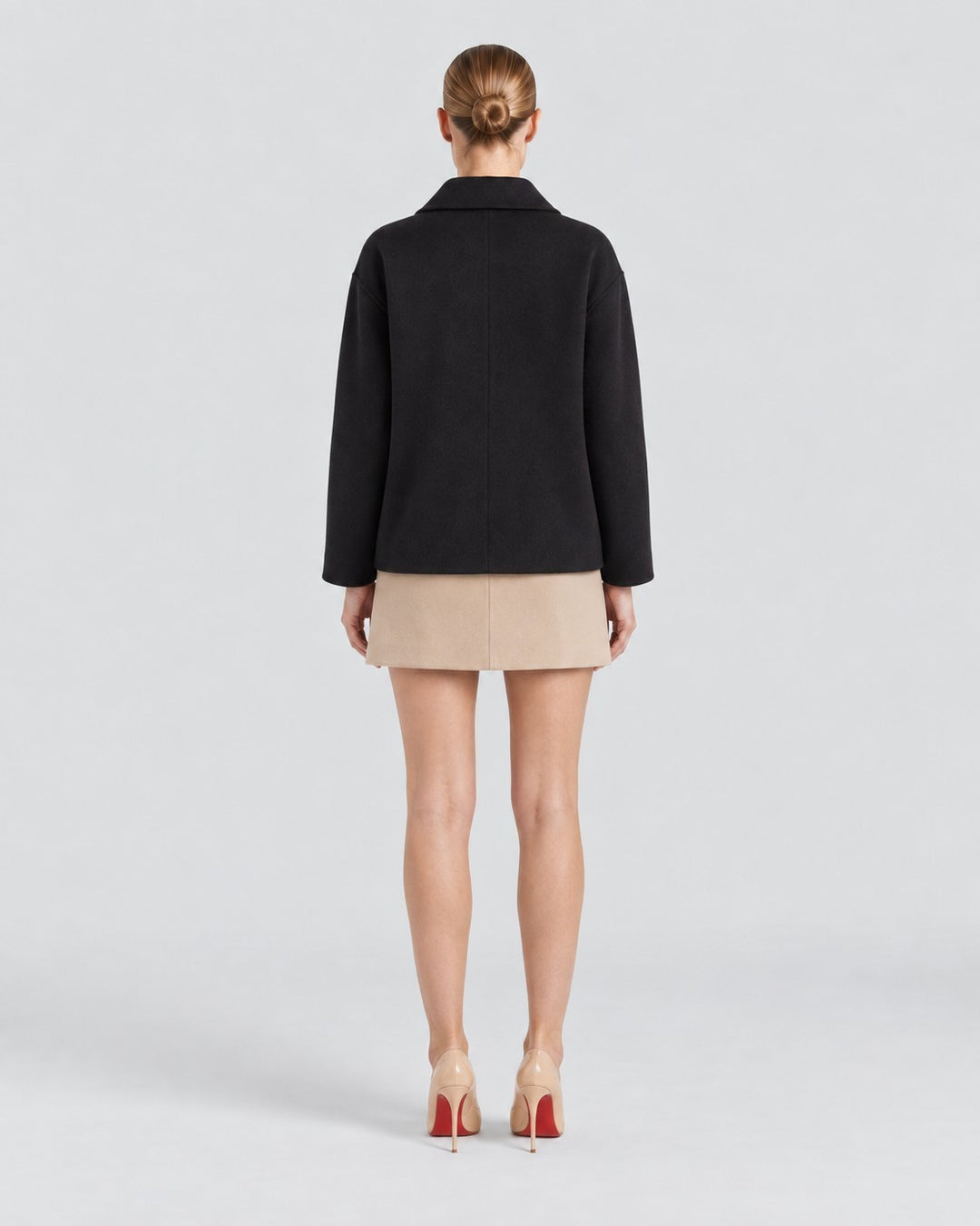 Luna Moda Amanda black oversized coat worn by a model from the back view with a beige skirt and heels