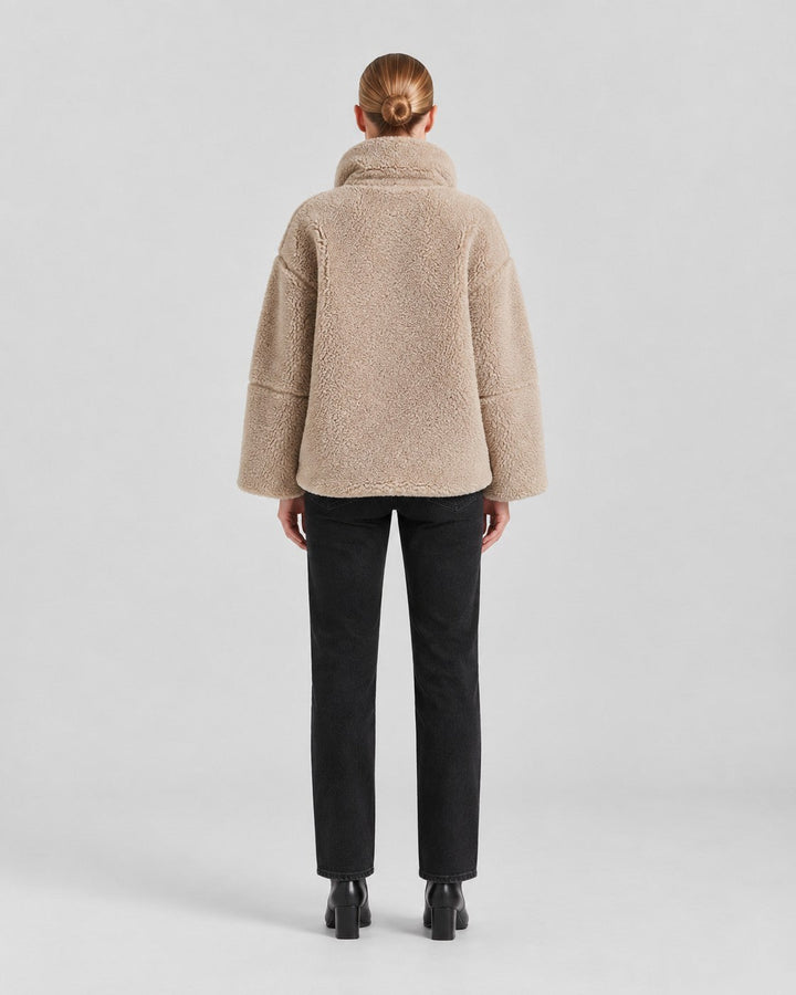 Luna Moda Anastasia beige fleece coat with a loose fit and high collar, worn by a woman from the back view.