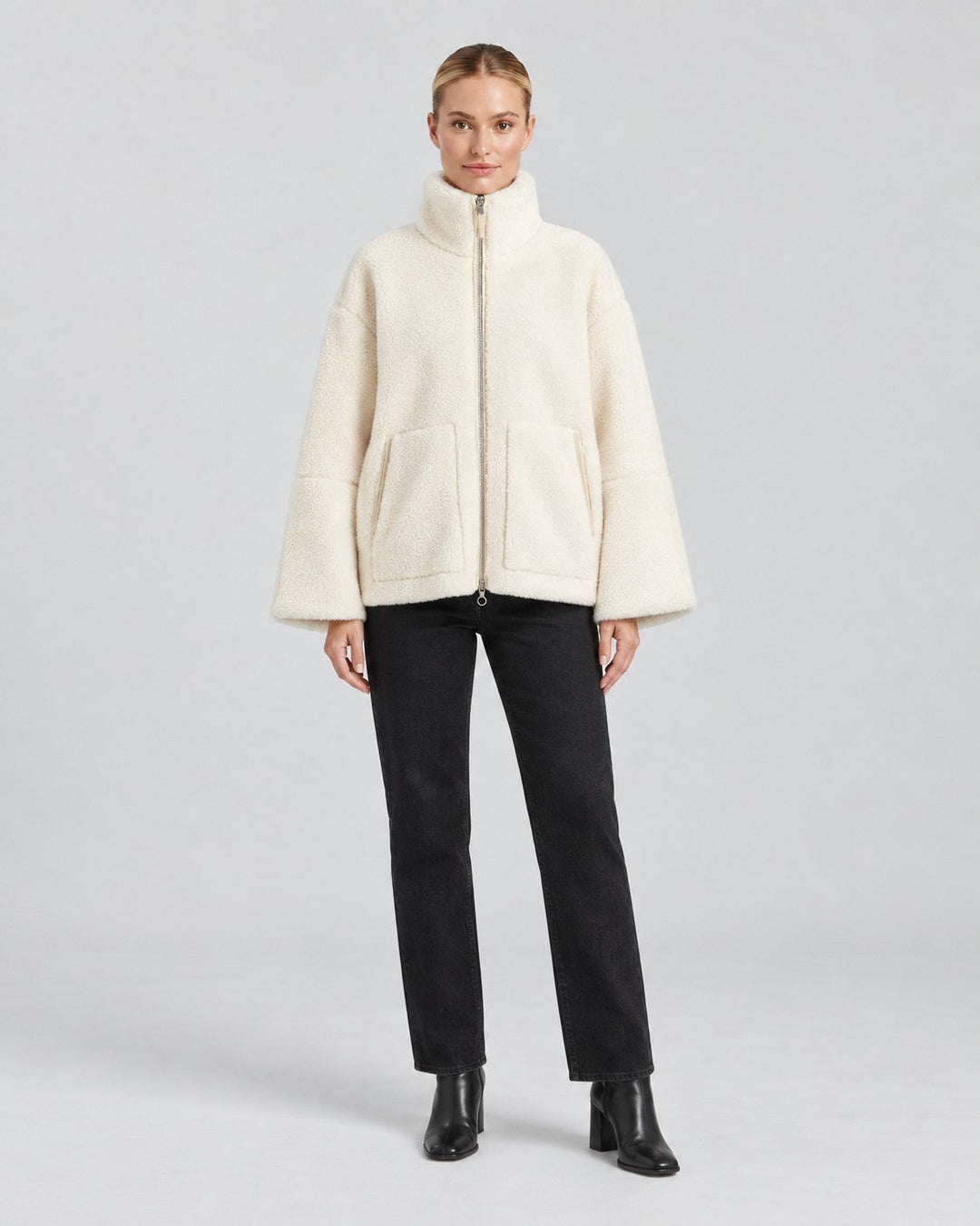 Luna Moda Anastasia cream fleece zip-up jacket with hood and pockets worn by a model with black trousers