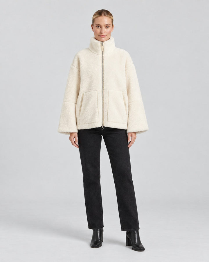 Luna Moda Anastasia cream fleece zip-up jacket with hood and pockets worn by a model with black trousers
