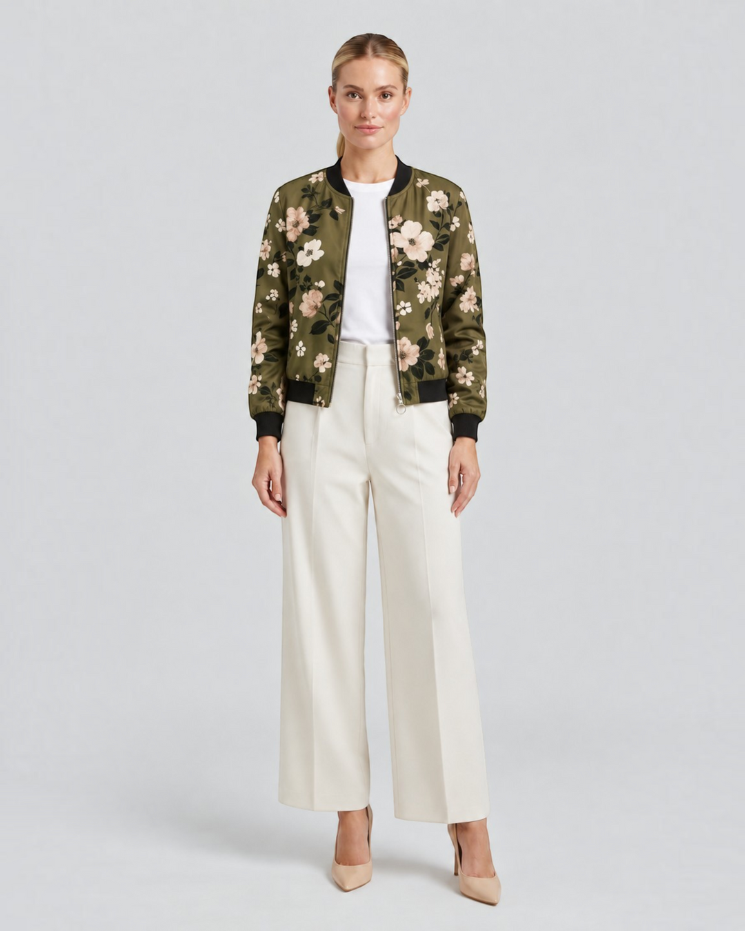Luna Moda Arianna bomber jacket in olive green with floral print, worn by a model with white trousers and heels.