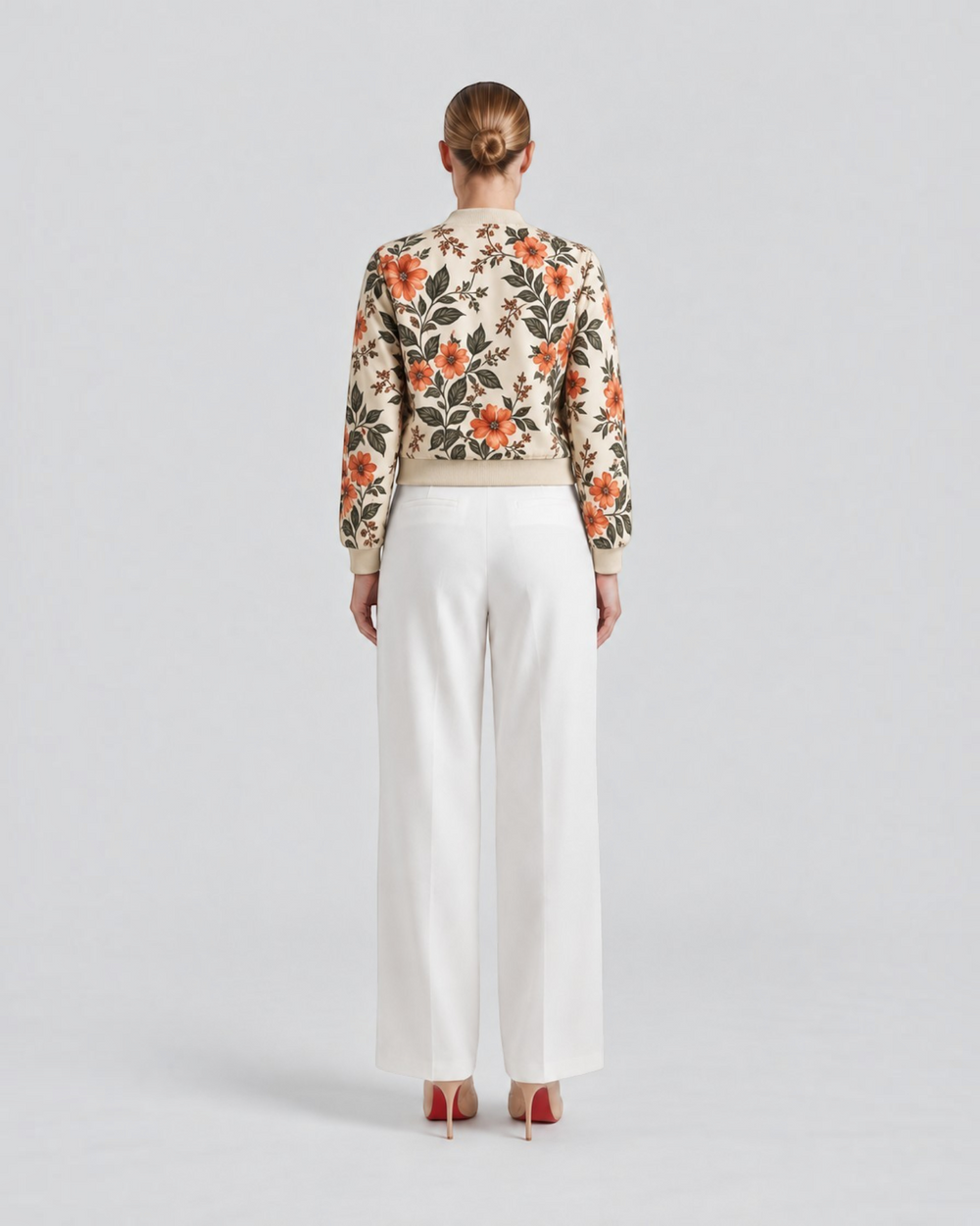 Luna Moda Arianna bomber jacket with vibrant floral print on beige polyester, worn with white trousers, back view.