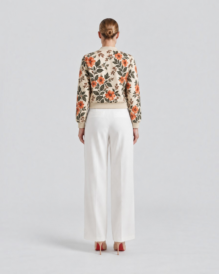 Luna Moda Arianna bomber jacket with vibrant floral print on beige polyester, worn with white trousers, back view.