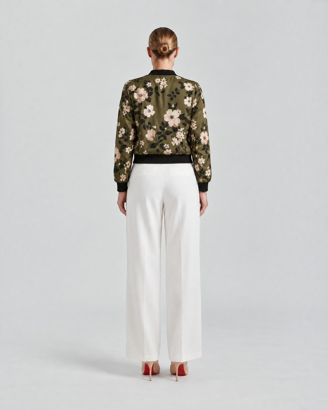 Luna Moda Arianna bomber jacket in olive green with floral print, worn with white trousers, back view.