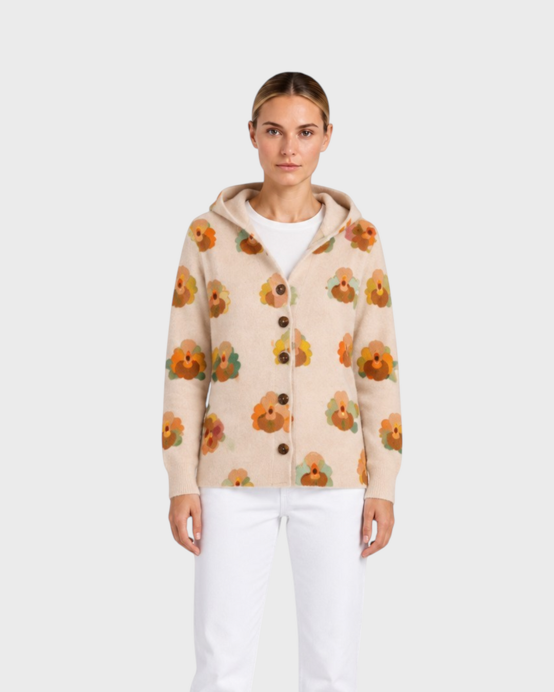 Luna Moda Arianna beige knit cardigan with a hood and orange floral pattern worn by a model with white jeans.