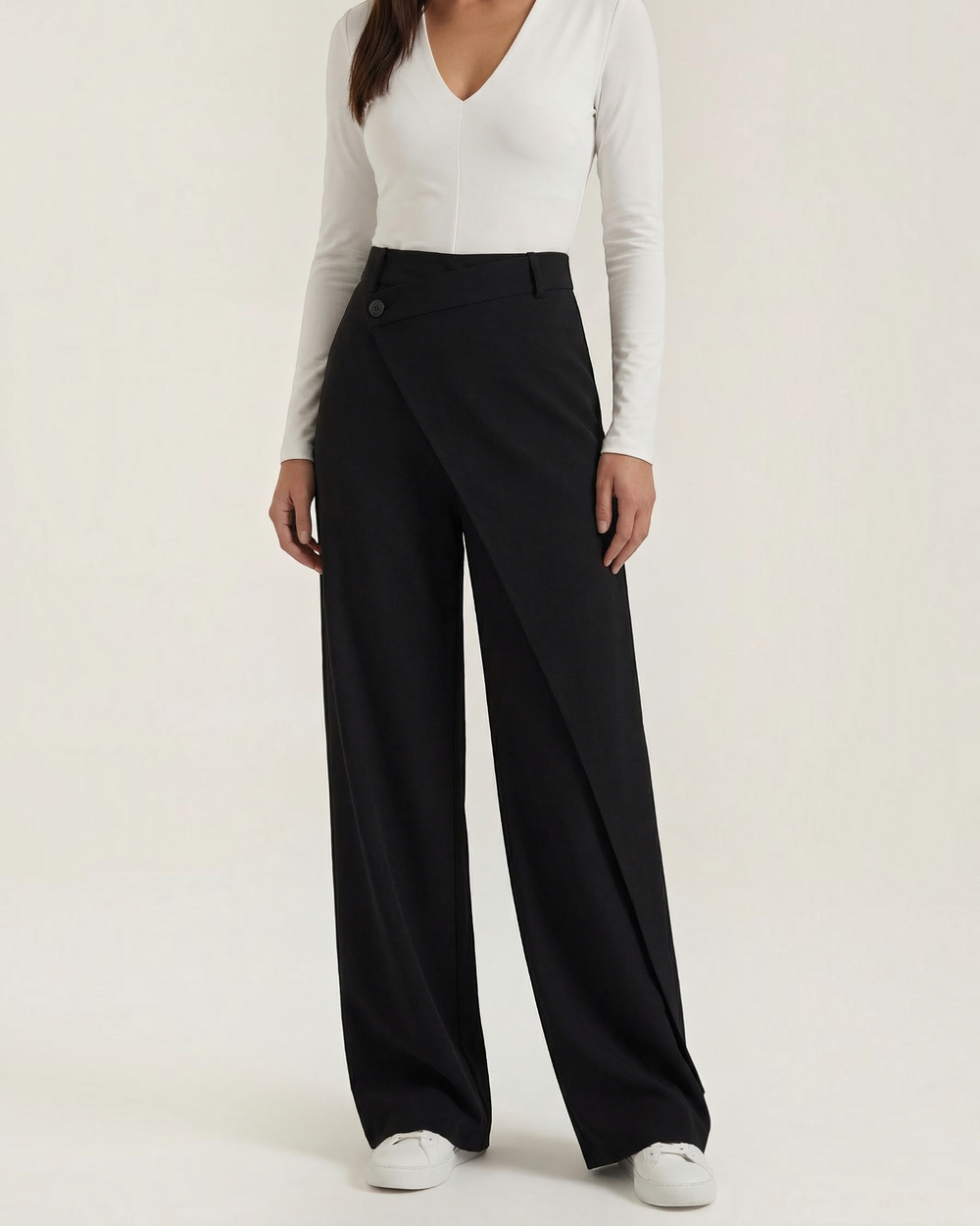 Luna Moda Licia black wide-leg trousers featuring an asymmetrical front wrap panel and button detail.