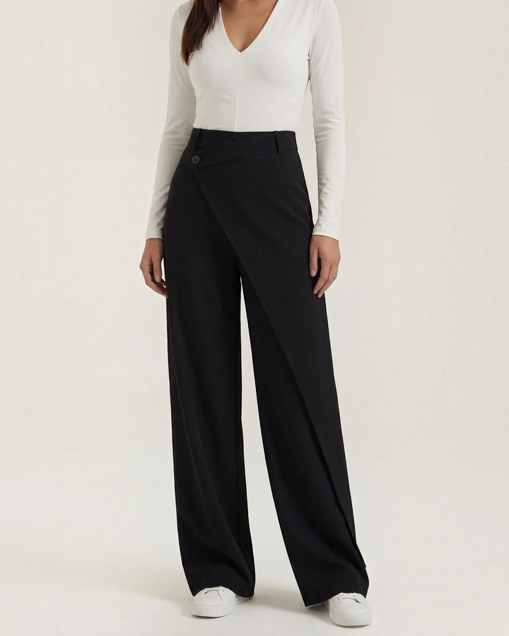 Luna Moda Licia black wide-leg trousers featuring an asymmetrical front wrap panel and button detail.