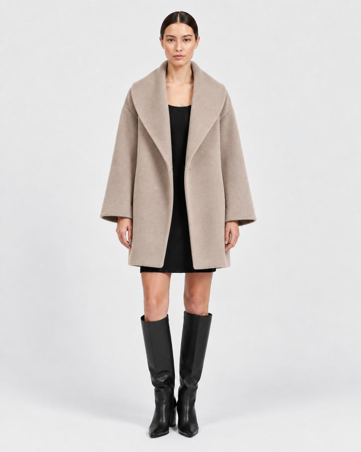 Luna Moda beige wool-blend coat with a wide collar worn by a model over a black dress and knee-high boots