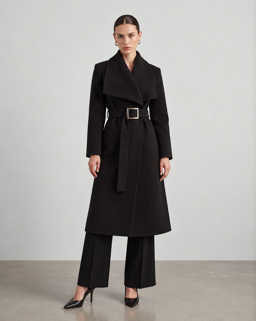Luna Moda black long coat with a wide collar and belted waist worn by a model in a studio setting