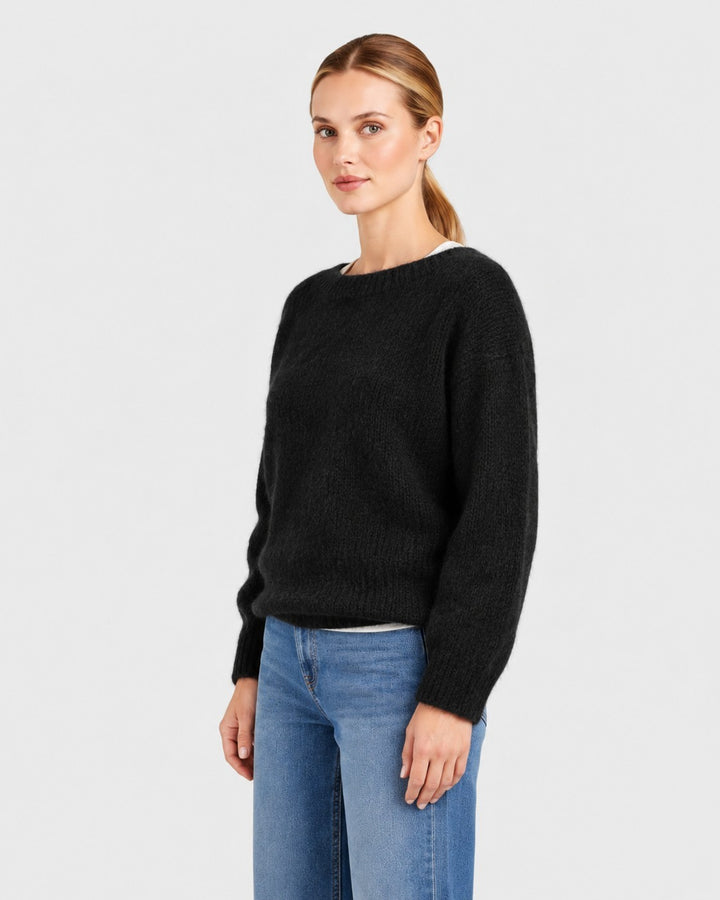 Luna Moda Elda black crew neck sweater with a soft, relaxed fit worn by a woman with blue jeans.