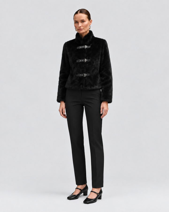 Luna Moda black cropped faux fur jacket with leather buckle closures worn by a model with black trousers