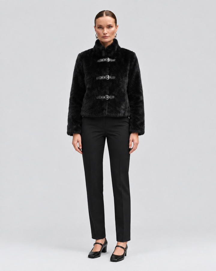 Luna Moda black cropped faux fur jacket with three leather buckle closures worn by a model on a grey background.