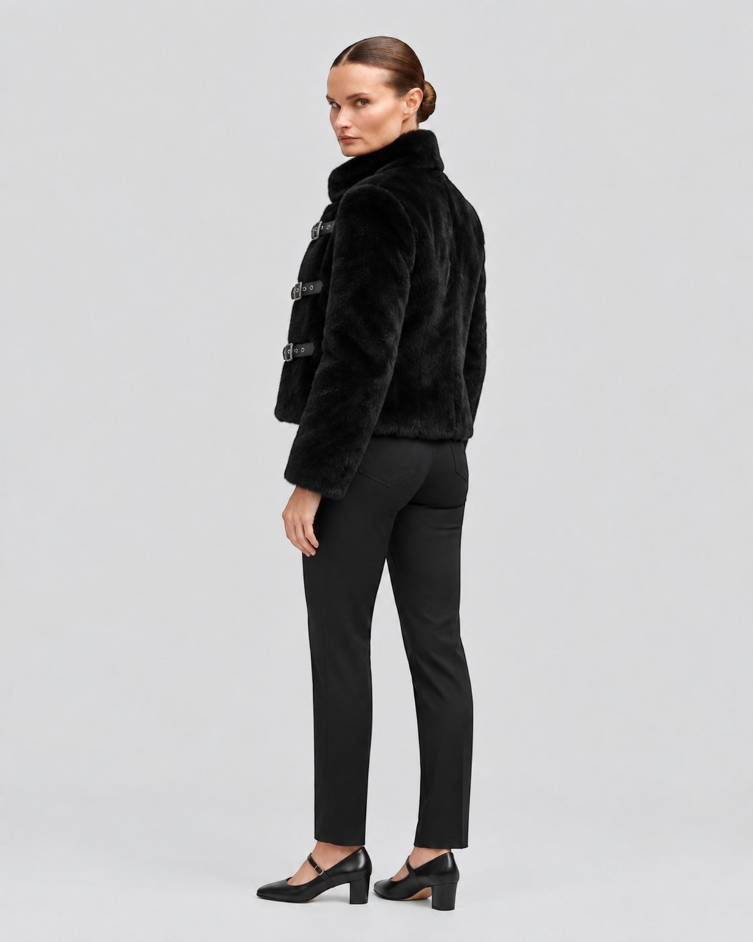 Luna Moda black cropped faux fur jacket with leather buckle closures worn by a model against a neutral background