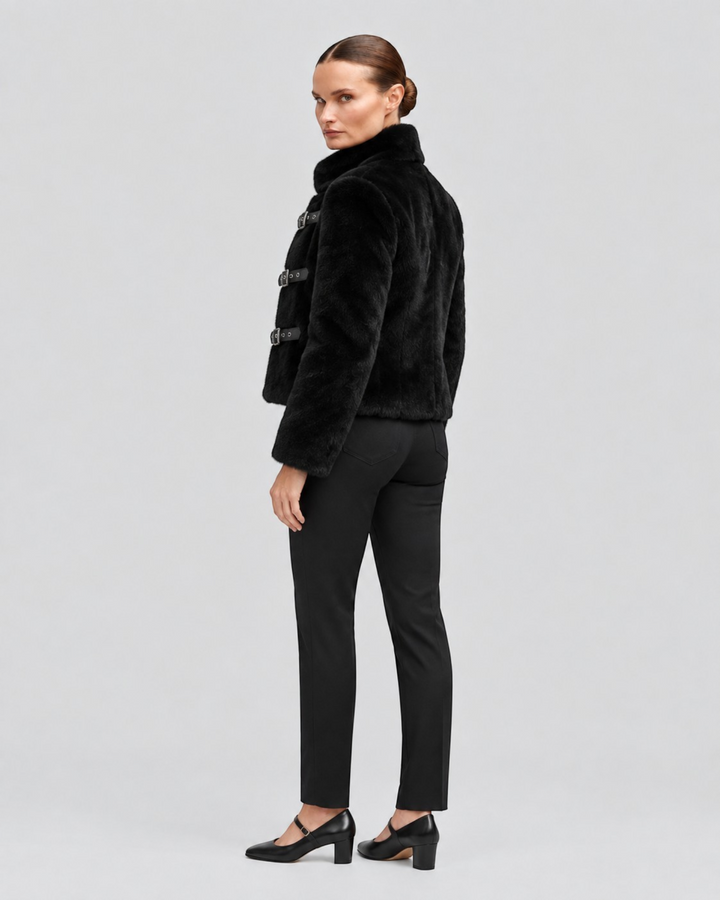 Luna Moda black cropped faux fur jacket with leather buckle closures worn by a model against a neutral background