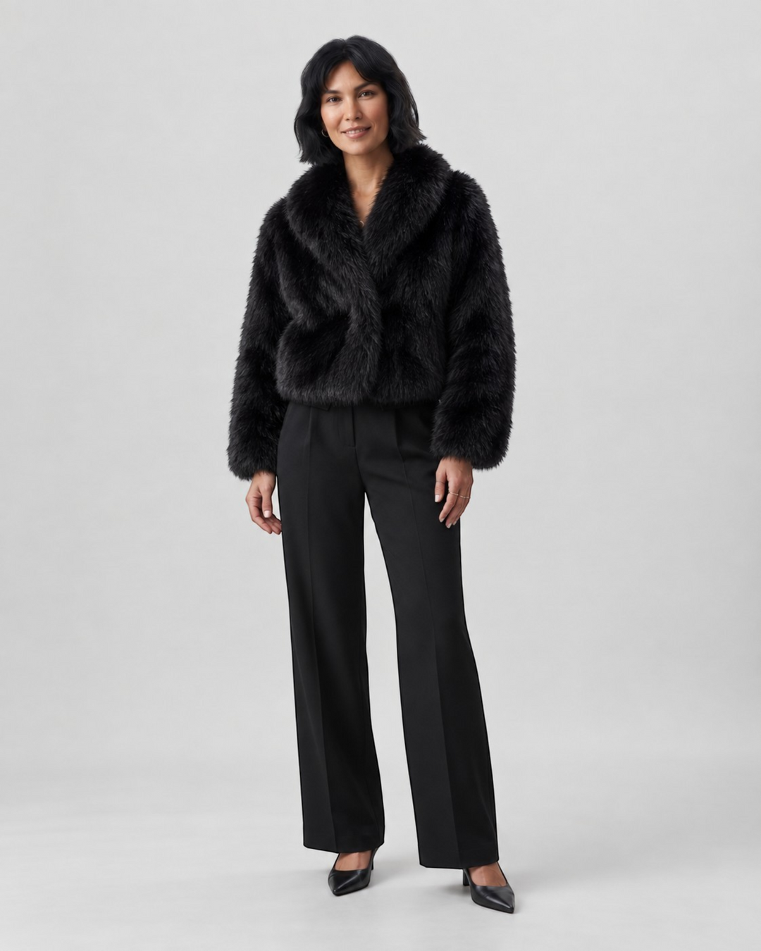 Luna Moda Margherita black faux fur cropped coat with wide collar worn by a model with black trousers and heels