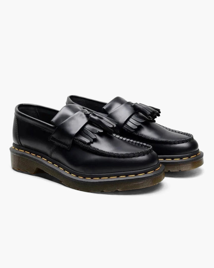 Luna Moda black leather loafers featuring a classic tassel design, fringe detail, and durable yellow-stitched soles.