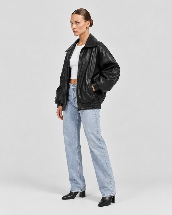 Luna Moda black oversized PU leather bomber jacket worn by a model with light wash jeans and black heeled boots.