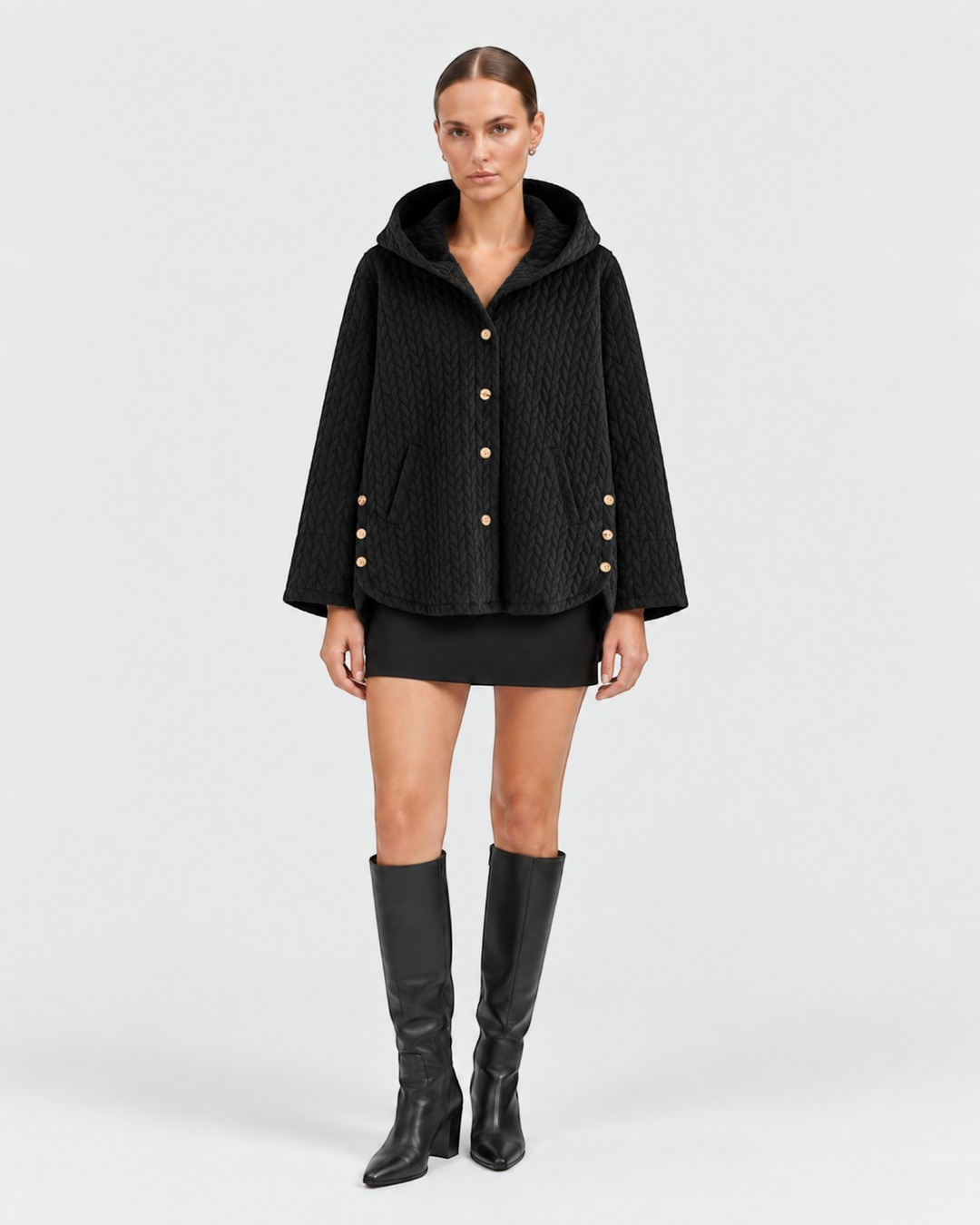 Luna Moda black quilted hooded jacket with decorative gold buttons worn by a model with a black mini skirt and boots