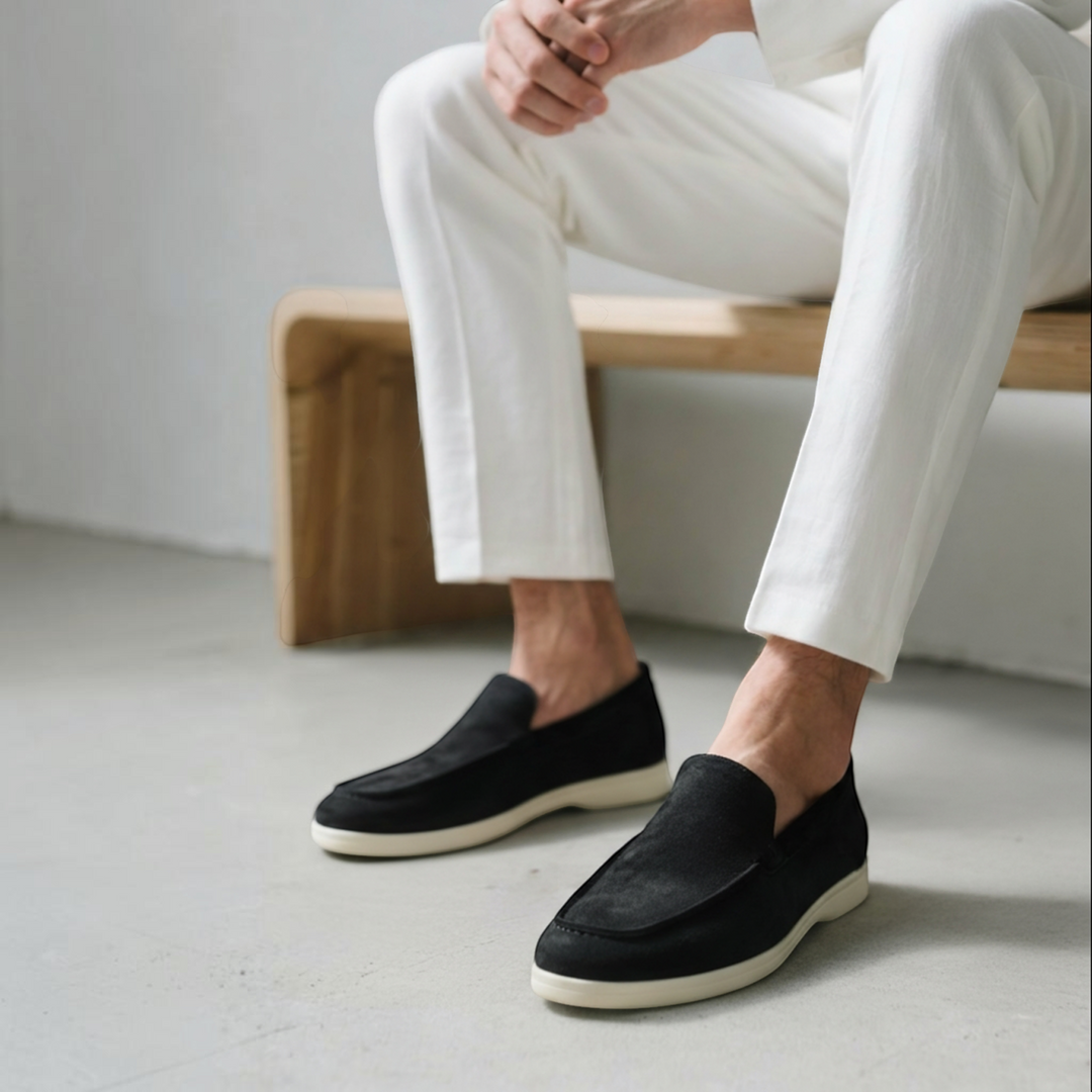 Luna Moda Romeo black suede loafers with supportive white soles worn by a man in white trousers