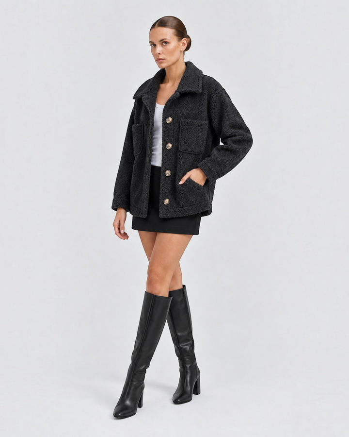 Luna Moda black short teddy jacket with lapels, front buttons, and pockets worn by a model with black knee-high boots