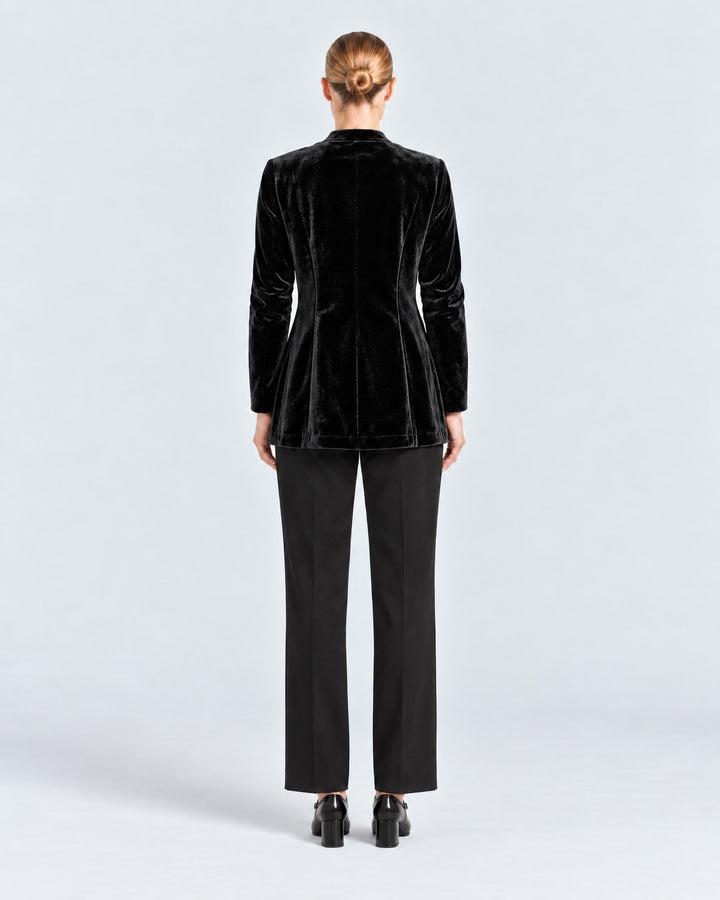 Back view of a model wearing a Luna Moda black velvet blazer with long sleeves and a tailored fit.