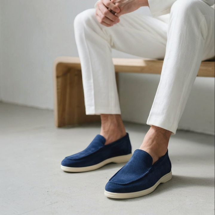 Luna Moda blue suede loafers with supportive white soles worn by a man in white trousers