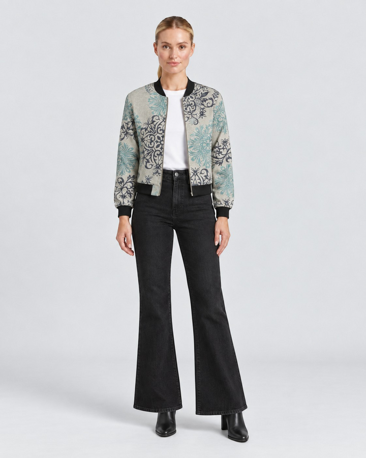 Luna Moda Sofia bomber jacket with botanical print in grey and teal, worn by a model with black flared jeans.
