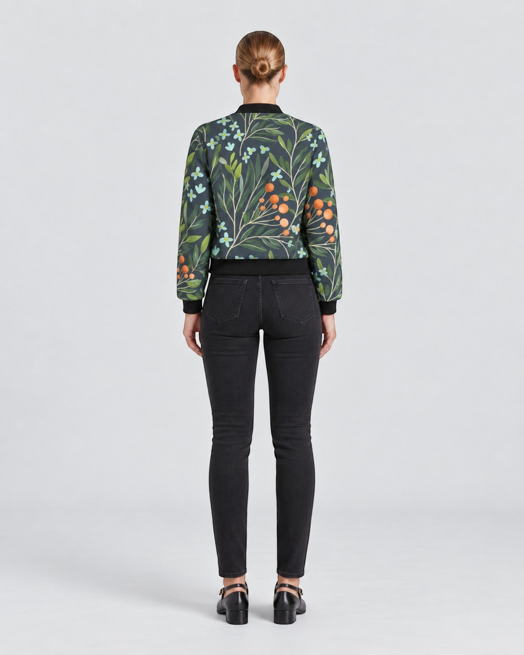 Luna Moda Sofia bomber jacket with botanical print, dark green background, orange berries, and black ribbed trim.