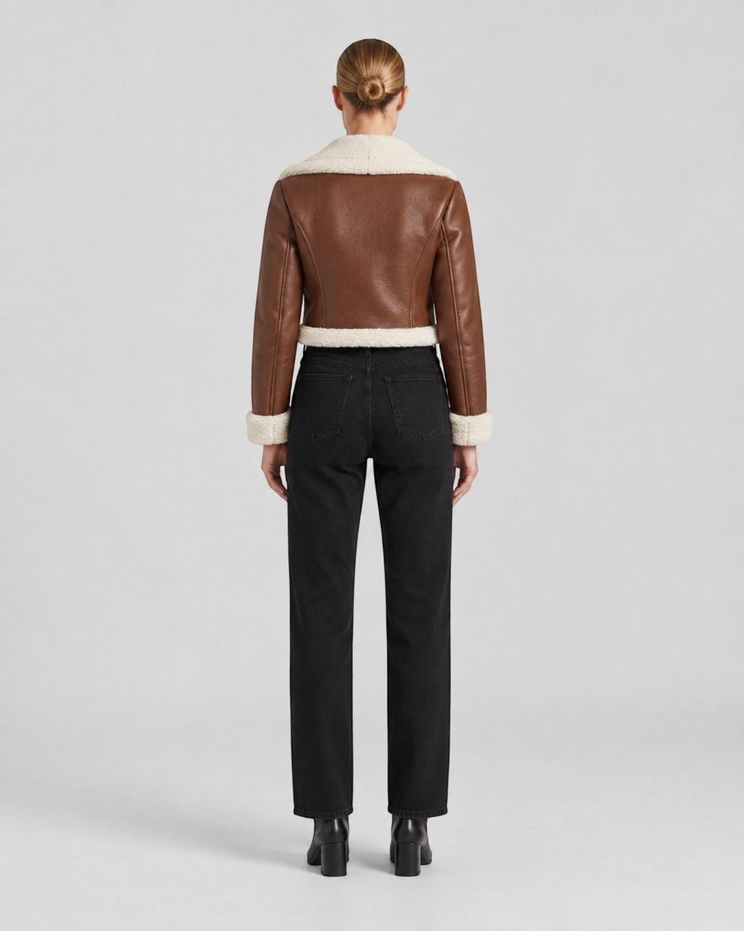 Luna Moda brown cropped faux leather jacket with white fleece lining, back view on a model wearing black jeans.
