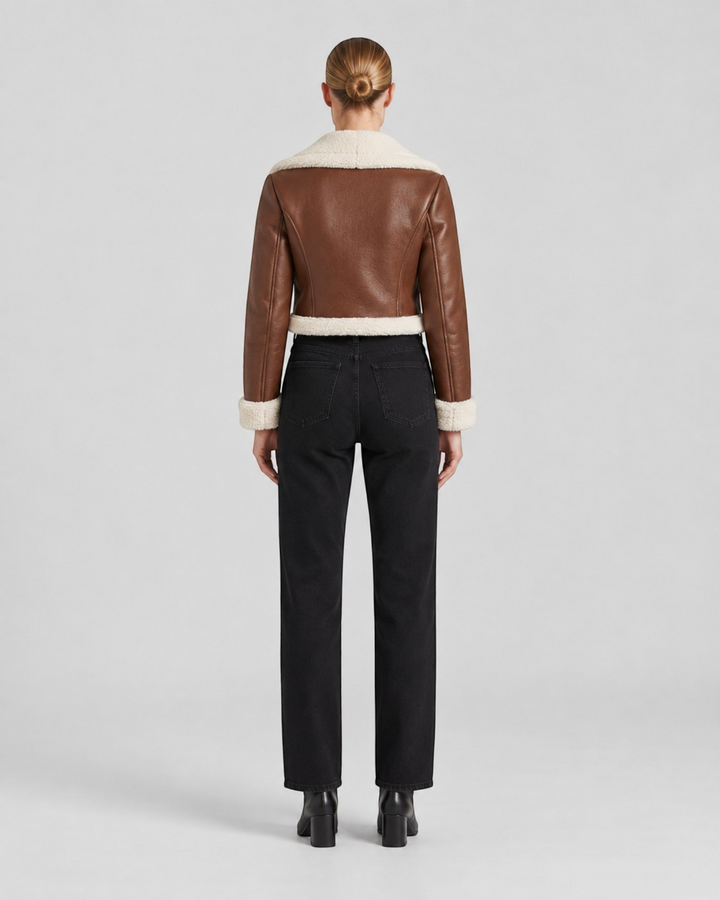 Luna Moda brown cropped faux leather jacket with white fleece lining, back view on a model wearing black jeans.